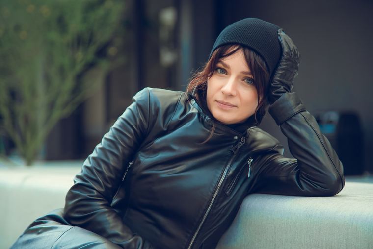 Olya reclining in a black leather jacket and beanie
